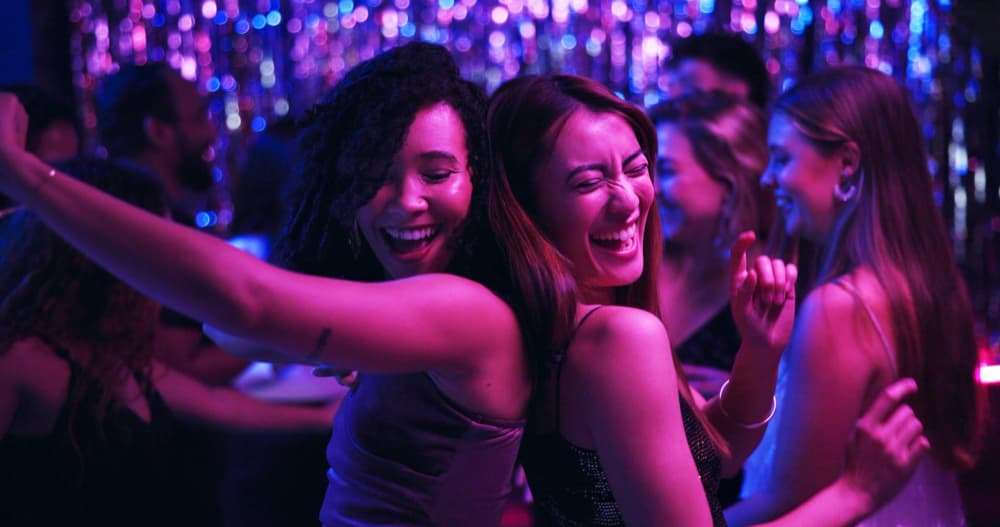 Crowded nightclub dancefloor with people dancing during a late-night DJ set